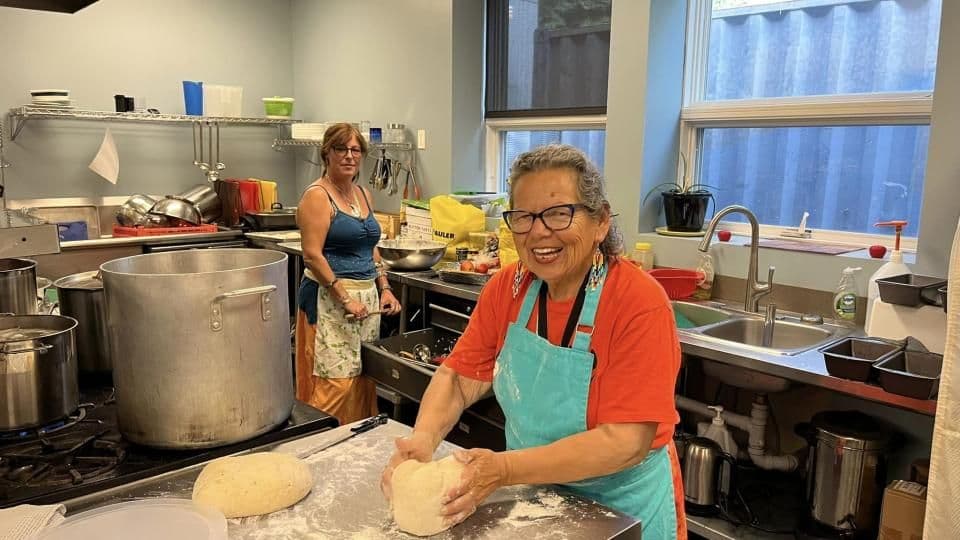 A community Grandmother cooking up a feast — made with lots of love